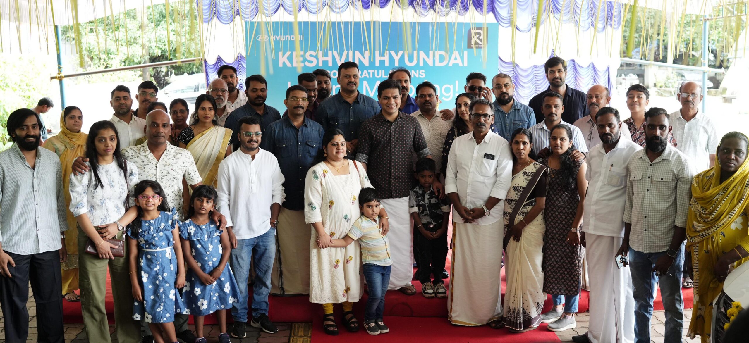 MP Hibi Eden with families who received their cars at the Keshvin Hyundai delivery ceremony in Kochi. CEO Sanjulal Ravindran and GM Danish P. Davis are also seen
